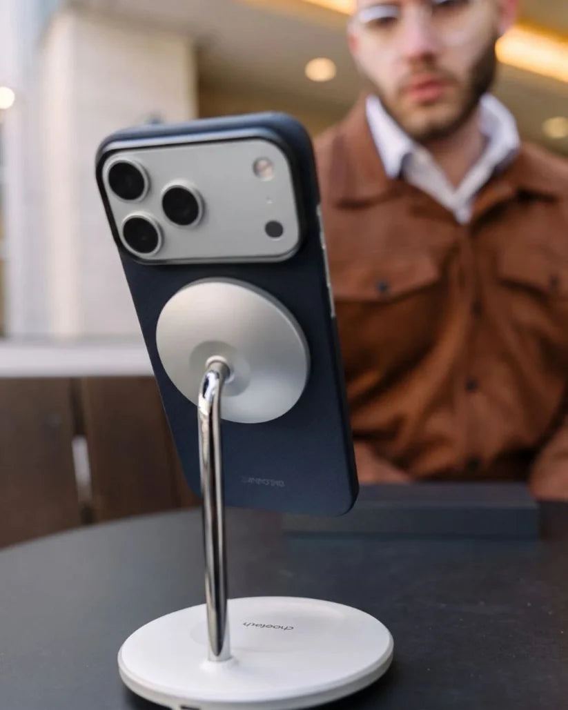 Thinborne navy aramid fiber iPhone 18 Pro Max case mounted on MagSafe desk stand, cafe lifestyle shot