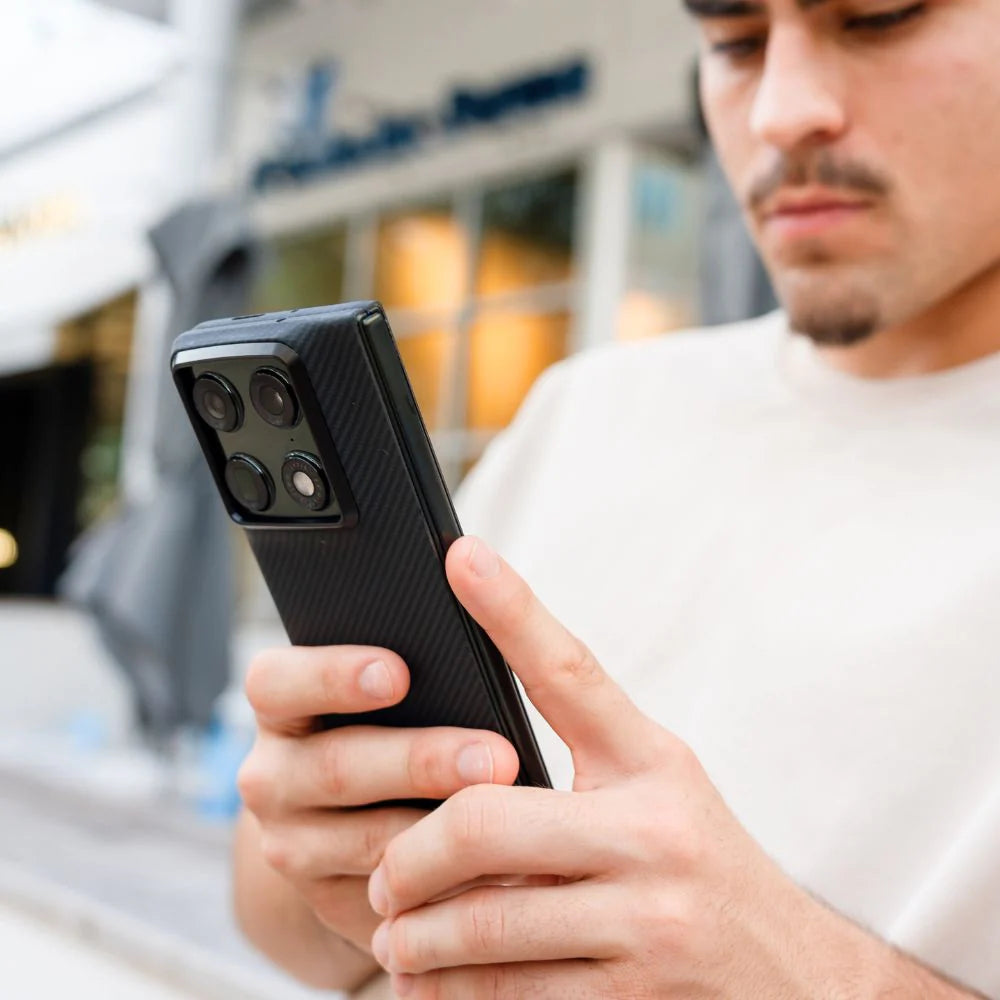 Man holding Motorola Razr Fold horizontal foldable phone fitted with black carbon fiber textured case, urban outdoor lifestyle shot, thin premium foldable phone shell