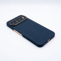 Navy blue aramid fiber Pixel 11 Pro case angled studio shot, carbon‑weave texture, gold metal buttons and precise port cutouts