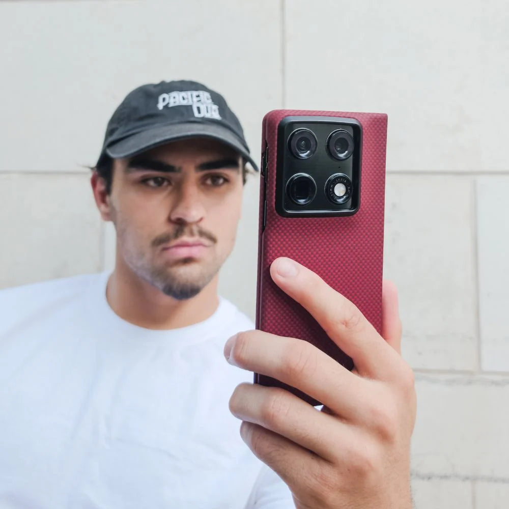Lifestyle shot, man holding Motorola Razr Fold equipped with Super Thin Crimson woven carbon fiber case, outdoor street portrait