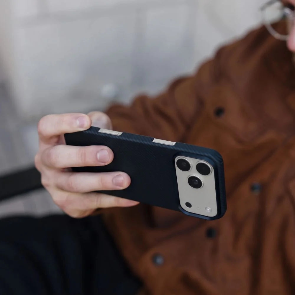 Hand holding Thinborne iPhone 18 Pro Max aramid fiber case, side grip view with textured surface