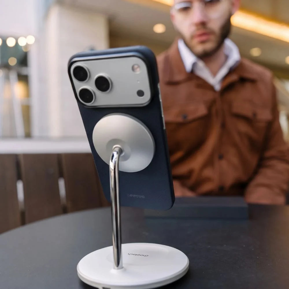Thinborne iPhone 18 Pro Max Case mounted on MagSafe stand, aramid fiber magnetic phone holder desk demo, lifestyle outdoor cafe shot