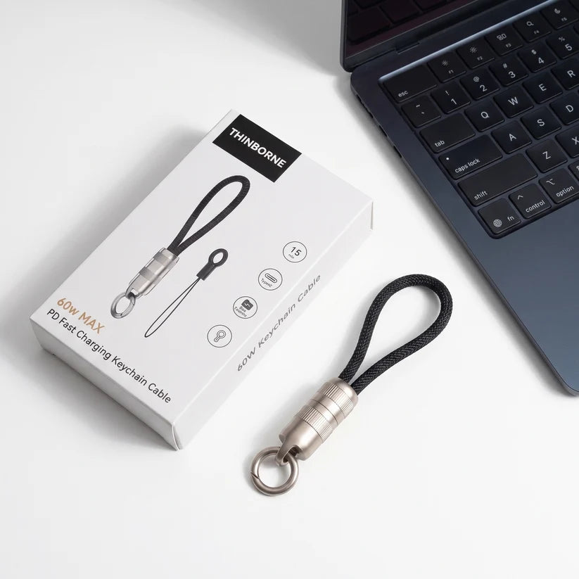 Ultra Short Keychain Cable displayed with retail packaging, compact portable charging keychain cable next to laptop